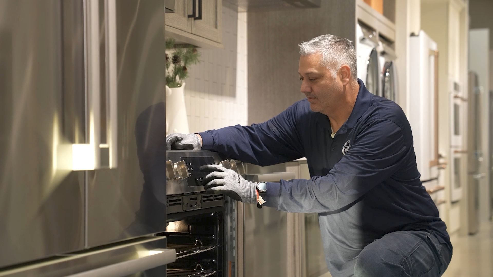 A Yale Appliance technician working on the controls of a slide-in range